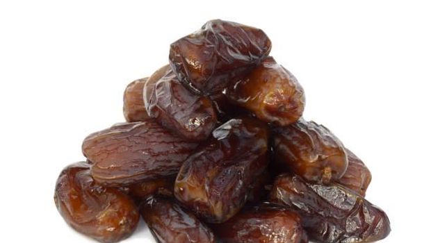 Pile of Deglet Nour dates grown in Tunisia, on a white background. Deglet Nour dates have a characteristic translucent blond colour and soft caramel-like taste which distinguishes them from all other dates.