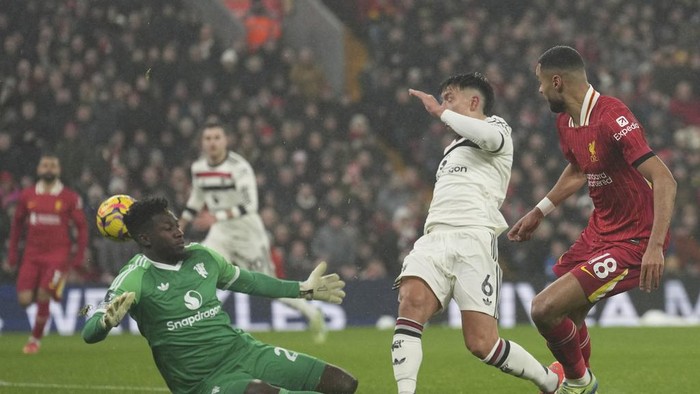 Liverpools Cody Gakpo, right, Manchester Uniteds Lisandro Martinez, center, and goalkeeper Andre Onana battle for the ball during the English Premier League soccer match at the Anfield stadium in Liverpool, England, Sunday, Jan. 5, 2025. (AP Photo/Jon Super)