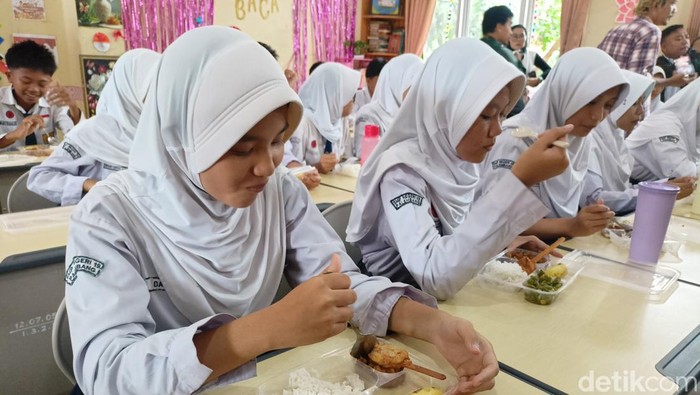 Siswa di Sekolah Menengah Pertama Negeri 19 Palembang menikmati masakan gratis di Palembang. Siswa di Sekolah Menengah Pertama Negeri 19 Palembang menikmati masakan gratis di Palembang.