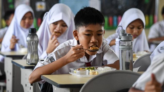 Siswa menyantap makanan bergizi gratis saat pelaksanaan Program Makan Bergizi Gratis (MBG) di SD Negeri 25 Palembang, Sumatera Selatan, Senin (6/1/2025).   Pelaksanaan perdana Program Makan Bergizi Gratis (MBG) di Kota Palembang tersebut baru dilaksanakan di lima sekolah yang berada dilingkungan Kecamatan Ilir Barat (IB) 1, Palembang  yaitu TK Panca Bakti, SDN 24, SDN 25, SMPN 19 dan SMPN 33 dengan total siswa sebanyak 2.968 siswa. ANTARA FOTO/Nova Wahyudi/nz