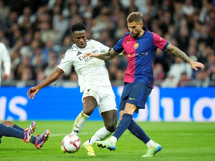 Vinicius Junior left winger of Real Madrid and Brazil and Iñigo Martinez centre-back of Barcelona and Spain compete for the ball during the La Liga match between Real Madrid CF and FC Barcelona at Estadio Santiago Bernabeu on October 27, 2024 in Madrid, Spain. (Photo by Jose Breton/Pics Action/NurPhoto via Getty Images)