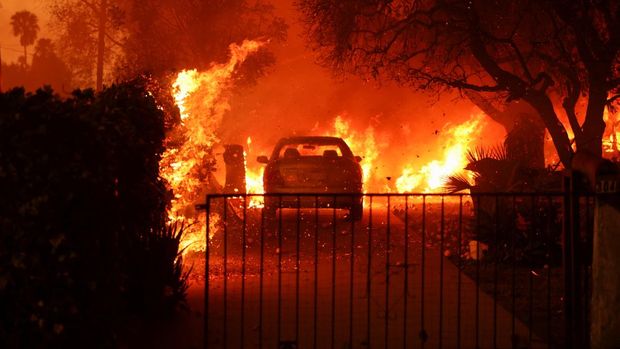 A parked vehicle is surrounded by flames as powerful winds fueling devastating wildfires in the Los Angeles area force people to evacuate, at the Eaton Fire in Altadena, California, U.S. January 8, 2025. REUTERS/David Swanson