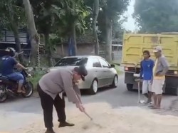 Polisi Bantu Warga Uruk Jalan di Modo Lamongan yang Berlubang