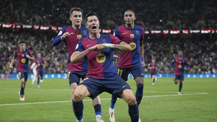 Barcelona's Robert Lewandowski, centre, celebrates after scoring his side's second goal during the Spain Super Cup final soccer match between Real Madrid and Barcelona at King Abdullah Stadium in Jeddah, Saudi Arabia, Sunday, Jan. 12, 2025. (AP Photo/Altaf Qadri)