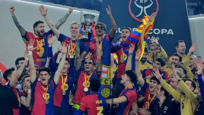 Soccer Football - Spanish Super Cup - Final - FC Barcelona v Real Madrid - King Abdullah Sports City, Jeddah, Saudi Arabia - January 12, 2025 FC Barcelonas Lamine Yamal celebrates with the trophy and teammates after winning the Spanish Super Cup REUTERS/Stringer