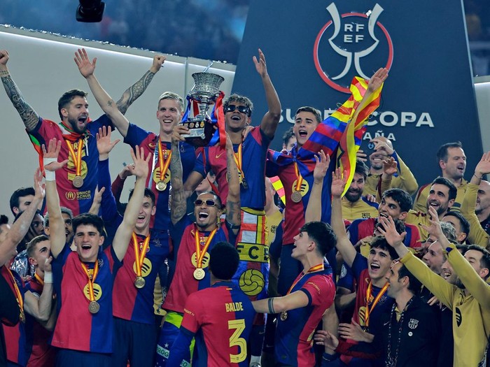 Soccer Football - Spanish Super Cup - Final - FC Barcelona v Real Madrid - King Abdullah Sports City, Jeddah, Saudi Arabia - January 12, 2025 FC Barcelona's Lamine Yamal celebrates with the trophy and teammates after winning the Spanish Super Cup REUTERS/Stringer