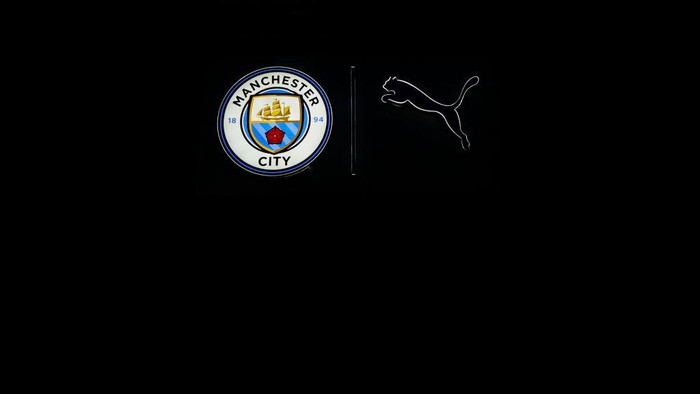 MANCHESTER, ENGLAND - NOVEMBER 26: An illuminated Manchester City emblem next to a Puma logo ahead of the UEFA Champions League 2024/25 League Phase MD5 match between Manchester City and Feyenoord at City of Manchester Stadium on November 26, 2024 in Manchester, England. (Photo by Robbie Jay Barratt - AMA/Getty Images)
