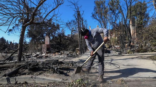 Employees of Hart Built Construction clean the streets of the Pacific Palisades neighborhood of Los Angeles, California, on January 14, 2025, in the aftermath of the Palisades Fire. Powerful winds forecast for late January 14 threatened to whip up massive fires that are still burning around Los Angeles in a tragedy that has killed at least 25 people and badly shaken the city.VALERIE MACON / AFP