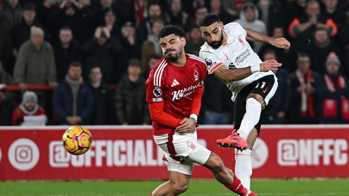 NOTTINGHAM, ENGLAND - JANUARY 14: (THE SUN OUT, THE SUN ON SUNDAY OUT) Mohamed Salah of Liverpool takes a shot whilst under pressure from Morgan Gibbs-White of Nottingham Forest during the Premier League match between Nottingham Forest FC and Liverpool FC at City Ground on January 14, 2025 in Nottingham, England. (Photo by Liverpool FC/Liverpool FC via Getty Images)
