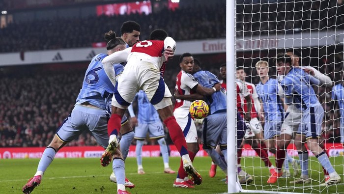 Arsenals Gabriel, centre, heads the ball as Tottenham Hotspurs Dominic Solanke scores own goal during the English Premier League soccer match between Arsenal and Tottenham Hotspur at the Emirates Stadium, London, Wednesday, Jan. 15, 2025. (Bradley Collyer/PA via AP)