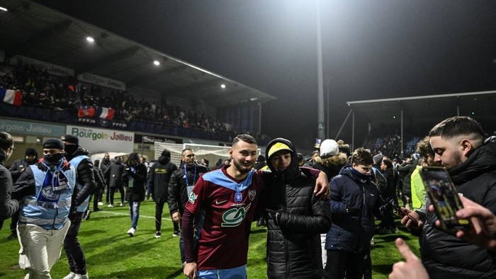 Bourgoin Jallieus Moroccan midfielder #09 Mehdi Moujetsky (C) celebrates with supporters after his teams victory at the end of the French Cup round of 32 football match between FC Bourgoin-Jallieu and Olympique Lyonnais (Lyon) at the Pierre-Rajon stadium in Bourgoin-Jallieu, central eastern France, on January 15, 2025. Bourgoin-Jallieu won and qualified for the French Cup round of 16. (Photo by JEFF PACHOUD / AFP)