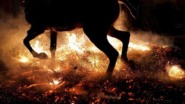 A horseman rides through a bonfire during the annual 