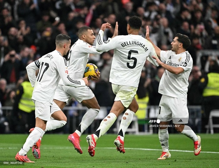 Real Madrids French forward #09 Kylian Mbappe celebrates with teammates after scoring from the penalty spot during Spanish league football match between Real Madrid CF and UD Las Palmas at the Santiago Bernabeu stadium in Madrid on January 19, 2025. (Photo by JAVIER SORIANO / AFP)