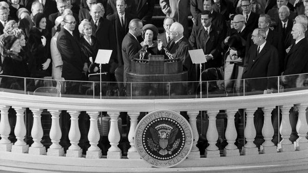 US President Lyndon Johnson (C) takes the oath of office on January 20, 1965 in Washington, DC, before US Attorney General Earl Warren (facing Johnson), while his wife Lady Bird Johnson looks on, during his inauguration ceremony as the 36th President of the United States. (Photo by AFP)