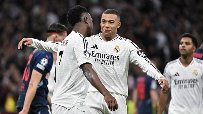 Real Madrids Brazilian forward #07 Vinicius Junior (L) is congratulated by Real Madrids French forward #09 Kylian Mbappe after scoring their fourth goal during the UEFA Champions League, league phase football match between Real Madrid CF and FC Salzburg at the Santiago Bernabeu stadium in Madrid on January 22, 2025. (Photo by JAVIER SORIANO / AFP)