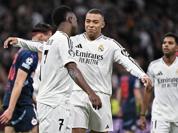 Real Madrid's Brazilian forward #07 Vinicius Junior (L) is congratulated by Real Madrid's French forward #09 Kylian Mbappe after scoring their fourth goal during the UEFA Champions League, league phase football match between Real Madrid CF and FC Salzburg at the Santiago Bernabeu stadium in Madrid on January 22, 2025. (Photo by JAVIER SORIANO / AFP)
