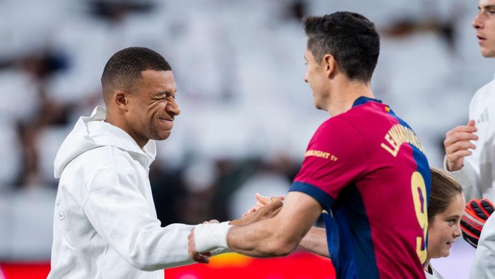 Kylian Mbappe of Real Madrid CF (L) cheers Robert Lewandowski of FC Barcelona (R) during the La Liga EA Sports 2024/25 football match between Real Madrid CF and FC Barcelona at Estadio Santiago Bernabeu in Madrid, Spain, on October 26, 2024. (Photo by Alberto Gardin/NurPhoto via Getty Images)