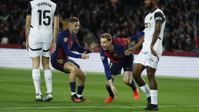 Barcelonas Frenkie de Jong, centre right, celebrates with Fermin Lopez after scoring the opening goal during the Spanish La Liga soccer match between Barcelona and Valencia at the Lluis Companys Olympic Stadium in Barcelona, Spain, Sunday, Jan. 26, 2025. (AP Photo/Joan Monfort)
