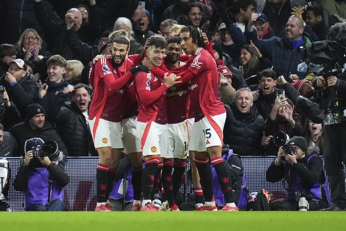 Manchester Uniteds Lisandro Martinez, center, is congratulated after scoring his sides opening goal during the English Premier League soccer match between Fulham and Manchester United at Craven Cottage stadium in London, Sunday, Jan. 26, 2025. (AP Photo/Kirsty Wigglesworth)