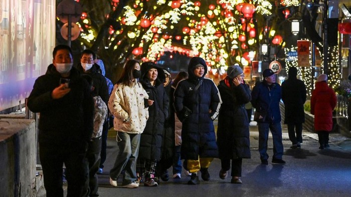 Warga China merayakan Tahun Baru Imlek di Beijing People walk in a street decorated with lanterns at a carnival on the eve of the Lunar New Year of the Snake in Beijing on January 28, 2025. (Photo by GREG BAKER / AFP)