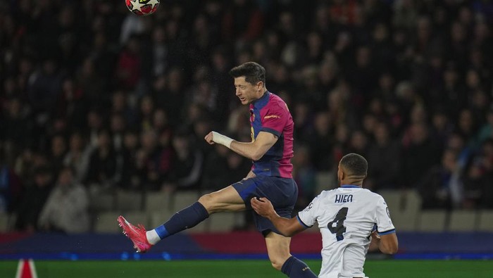 Barcelonas Robert Lewandowski, top, heads the ball next to Atalantas Isak Hien during a Champions League opening phase soccer between Barcelona and Atalanta match at the Lluis Companys Olympic stadium in Barcelona, Spain, Wednesday, Jan. 29, 2025. (AP Photo/Emilio Morenatti)