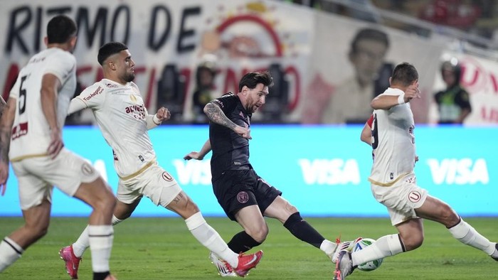 Lionel Messi, second from right, of the United States Inter Miami strikes the ball surrounded by players of Perus Universitario during an international friendly soccer match in Lima, Peru, Wednesday, Jan. 29, 2025. (AP Photo/Martin Mejia)