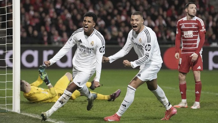 Real Madrids Rodrygo, left, celebrates with his teammate Kylian Mbappe after scoring his sides third goal during the Champions League opening phase soccer match between Brest and Real Madrid at Roudourou stadium in Guingamp, France, Wednesday, Jan. 29, 2025. (AP Photo/Thibault Camus)