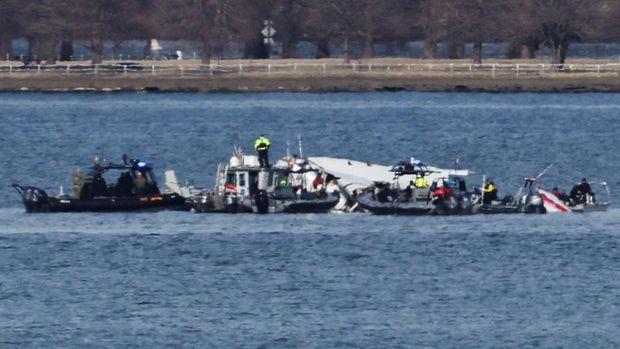 Emergency workers recover debris from the Potomac River in the aftermath of the collision of American Eagle flight 5342 and a Black Hawk helicopter, as seen from Virginia, U.S., January 30, 2025. REUTERS/Carlos Barria