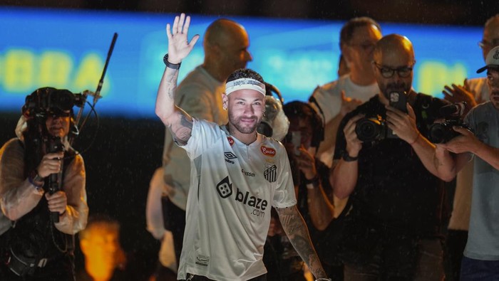 Brazilian soccer player Neymar, center, waves to fans during his presentation ceremony after signing a six-month contract with Santos FC at Vila Belmiro Stadium in Santos, Brazil, Friday, Jan. 31, 2025. (AP Photo/Andre Penner)