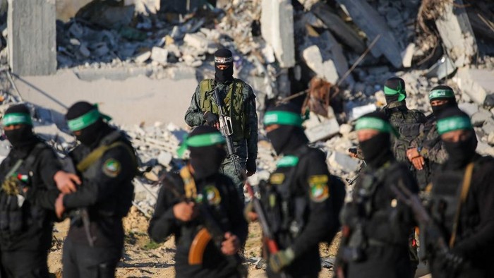 Para petempur Hamas mengamankan lokasi pembebasan dua sandera Israel di Jalur Gaza, yang diserahkan terhadap tim Palang Merah Internasional Palestinian militant group Hamas fighters secure an area before handing over two Israeli hostages to a Red Cross team in Khan Yunis on February 1, 2025, as part of fourth hostage-prisoner exchange. The Israeli military said the two freed hostages had now crossed into Israeli territory after they were released by Hamas on February 1. (Photo by Eyad BABA / AFP)