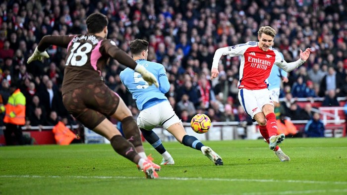 LONDON, ENGLAND - FEBRUARY 02: Martin Odegaard of Arsenal scores his teams first goal whilst under pressure from John Stones of Manchester City as Stefan Ortega of Manchester City fails to make a save during the Premier League match between Arsenal FC and Manchester City FC at Emirates Stadium on February 02, 2025 in London, England. (Photo by Justin Setterfield/Getty Images)
