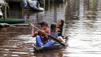 Mendayung Sampah di Banjir Tanah Putih Rohil