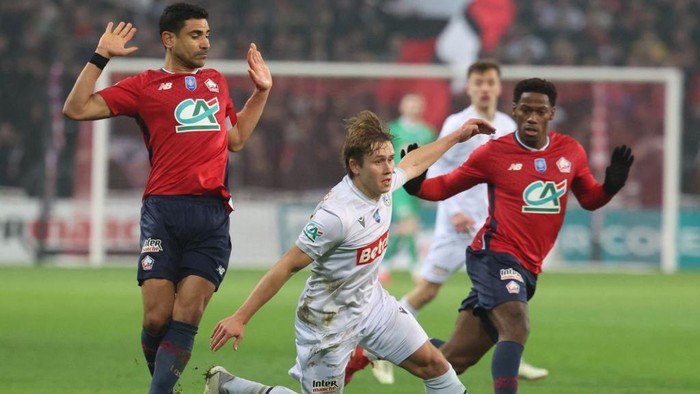 Dunkerques Finnish midfielder #10 Naatan Skytta (C) fights for the ball with Lilles French midfielder #06 Benjamin Andre (L) and Lilles Canadian forward #09 Jonathan David (R)   during the French Cup round of 16 football match between Lille OSC (LOSC) and USL Dunkerque at Pierre Mauroy Stadium, in Villeneuve-dAscq, northern France, on February 4, 2025. (Photo by FRANCOIS LO PRESTI / AFP)