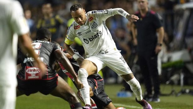Brazil's Neymar is tackled as he chases a ball during his debut for Santos FC in a Sao Paulo league soccer match against Botafogo-SP, in Santos, Brazil, Wednesday, Feb. 5, 2025. (AP Photo/Andre Penner)