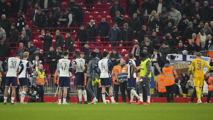 Tottenham players stand on the pitch after losing the English League Cup semifinal second leg soccer match between Liverpool and Tottenham Hotspur at Anfield Stadium in Liverpool, England, Thursday, Feb. 6, 2025. (AP Photo/Jon Super)