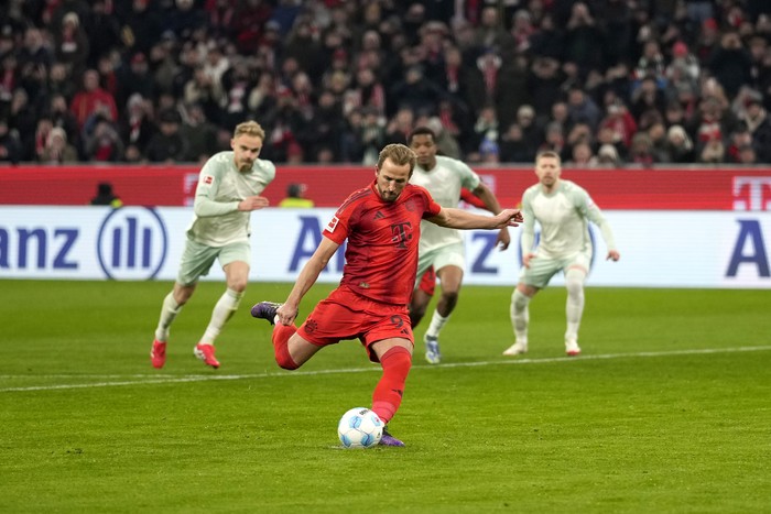 Bayern's Harry Kane, center, on his way to scoring on a penalty to score the first goal of the match during the German Bundesliga soccer match between Bayern Munich and Werder Bremen at the Allianz Arena in Munich, Germany, Friday, Feb. 7, 2025. (AP Photo/Matthias Schrader)