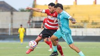 Pemain Madura United Luiz Marcelo Dos Reis berebut bola dengan pemain PSBS Biak Pablo Abel Arganaraz pada pertandingan BRI Liga 1. 