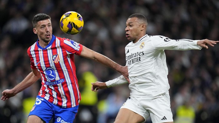 Atletico Madrids Clement Lenglet vies for the ball with Real Madrids Kylian Mbappe, right, during a Spanish La Liga soccer match between Real Madrid and Atletico Madrid at the Santiago Bernabeu stadium in Madrid, Saturday, Feb. 8, 2025. (AP Photo/Manu Fernandez)