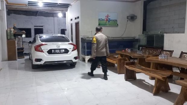 Mobil Honda Civic warna putih berpelat nomor B-412-SIN terparkir di rumah Kepala Desa Kohod, Arsin bin Sanip saat Bareskrim Polri menggeledah rumah tersebut.