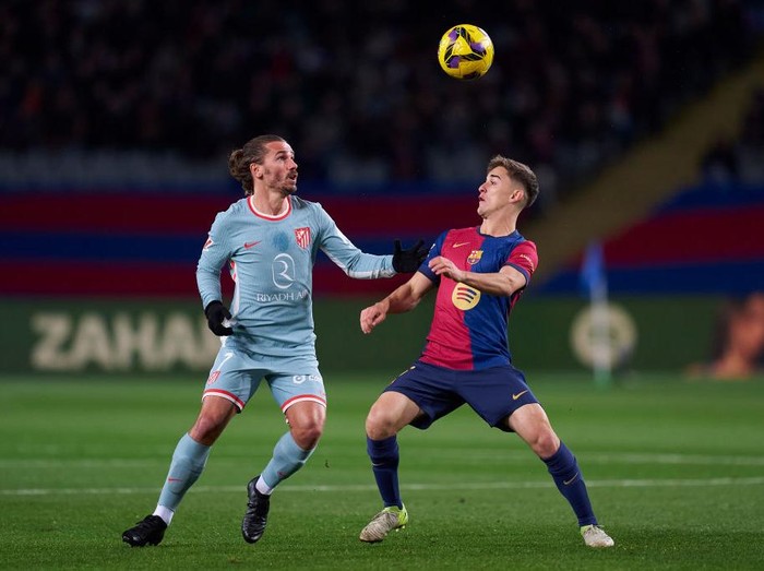 BARCELONA, SPAIN - DECEMBER 21:  Pablo Paez 'Gavi'  of FC Barcelona competes for the ball with Antoine Griezmann of Atletico de Madrid during the LaLiga EA Sports match between FC Barcelona and Atletico de Madrid at Estadi Olimpic Lluis Companys on December 21, 2024 in Barcelona, Spain. (Photo by Pedro Salado/Getty Images)
