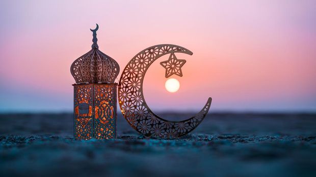 Ramadan Kareem photography, Lantern with crescent moon shape on the beach with sunset sky, 2024 Eid Mubarak  greeting background