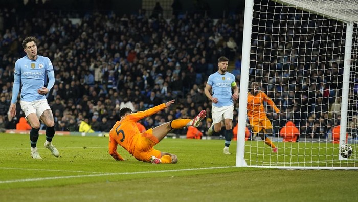 Real Madrids Jude Bellingham, center, scores his sides third goal during the Champions League playoff first leg soccer match between Manchester City and Real Madrid at the Etihad Stadium in Manchester, England, Tuesday, Feb. 11, 2025. (AP Photo/Dave Thompson)