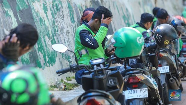 Pengemudi ojek online (ojol) menunggu orderan di area Palmerah, Jakarta, Rabu (12/2/2025). Masyarakat Transportasi Indonesia (MTI) mengusulkan agar ojek online di Jakarta bisa mendapatkan bahan bakar minyak (BBM) subsidi dengan langkah menggunakan plat kuning dalam upaya mendorong masyarakat untuk beranjak ke pikulan umum. (CNBC Indonesia/Faisal Rahman)