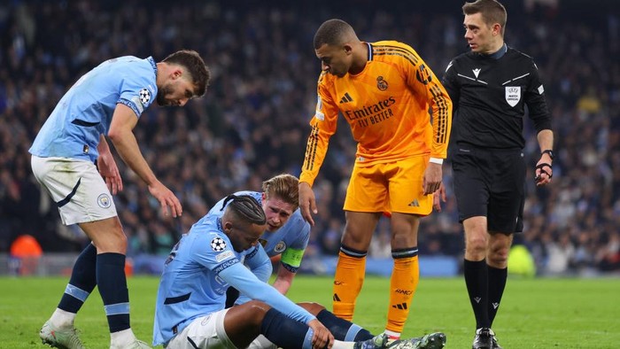 MANCHESTER, ENGLAND - FEBRUARY 11:  Manuel Akanji of Manchester City with Ruben Dias and Kevin De Bruyne after going down injured late in the first half during the UEFA Champions League 2024/25 League Knockout Play-off first leg match between Manchester City and Real Madrid C.F. at Manchester City Stadium on February 11, 2025 in Manchester, England. (Photo by Molly Darlington/Copa/Getty Images)