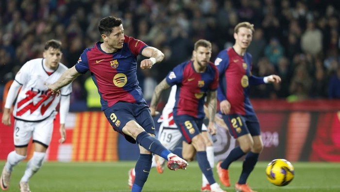 Barcelonas Robert Lewandowski scores his sides opening goal during a Spanish La Liga soccer match between Barcelona and Rayo Vallecano at the Lluis Companys Olympic Stadium in Barcelona, Spain, Monday, Feb. 17, 2025. (AP Photo/Joan Monfort)