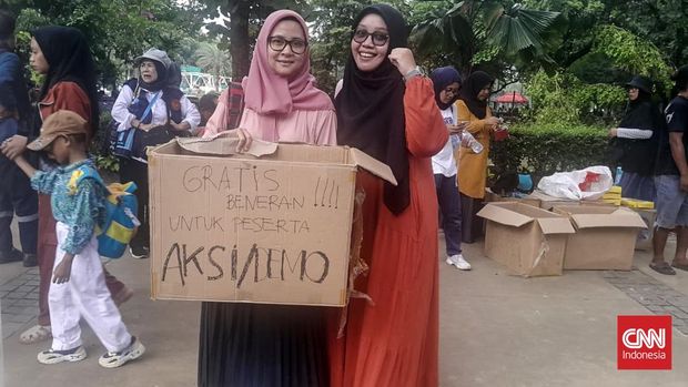 Sekelompok ibu-ibu membagikan makanan kepada peserta aksi Indonesia Gelap di Patung Kuda, Jakarta Pusat, Jumat (21/2).