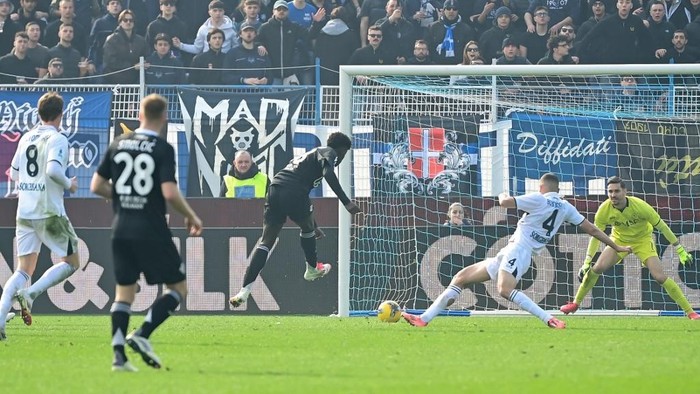 Comos Spanish forward #38 Assane Diao (C) shoots to score his teams second goal during the Italian Serie A football match between Como and Napoli at the Giuseppe-Sinigaglia Stadium in Como, on February 23, 2025. (Photo by Piero CRUCIATTI / AFP)