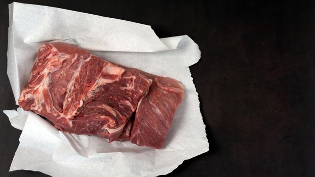 Meat on white paper, dark background.