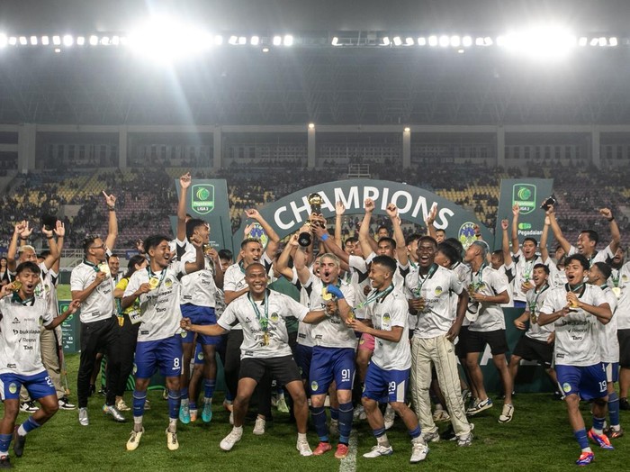 Pesepak bola PSIM Yogyakarta beserta offisial berselebrasi mengangkat piala usai mengalahkan Bhayangkara FC pada pertandingan final Pegadaian Liga 2 di Stadion Manahan, Solo, Jawa Tengah, Rabu (26/2/2025). PSIM Yogyakarta meraih juara pertama Liga 2 setelah di final menang atas Bhayangkara FC dengan skor 2-1. ANTARA FOTO/Mohammad Ayudha/YU