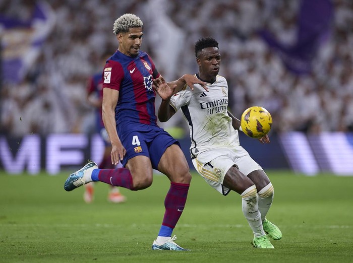 MADRID, SPAIN - 2024/04/21: Ronald Araujo (L) of FC Barcelona and Vinicius Junior (R) of Real Madrid CF in action during the 2023/2024 La Liga EA Sports week 32 football match between Real Madrid CF and FC Barcelona at Santiago Bernabeu stadium. Final score: Real Madrid CF 3:2 FC Barcelona. (Photo by Federico Titone/SOPA Images/LightRocket via Getty Images)